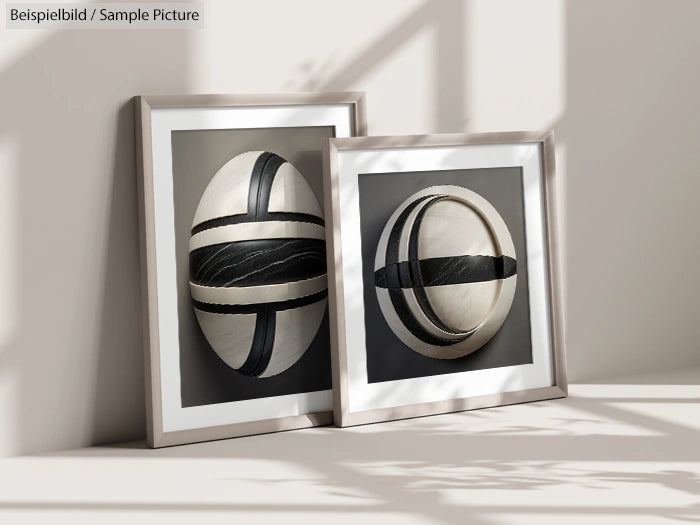 Two framed abstract artworks with geometric sphere designs, leaning against a wall with shadow patterns on the surface.