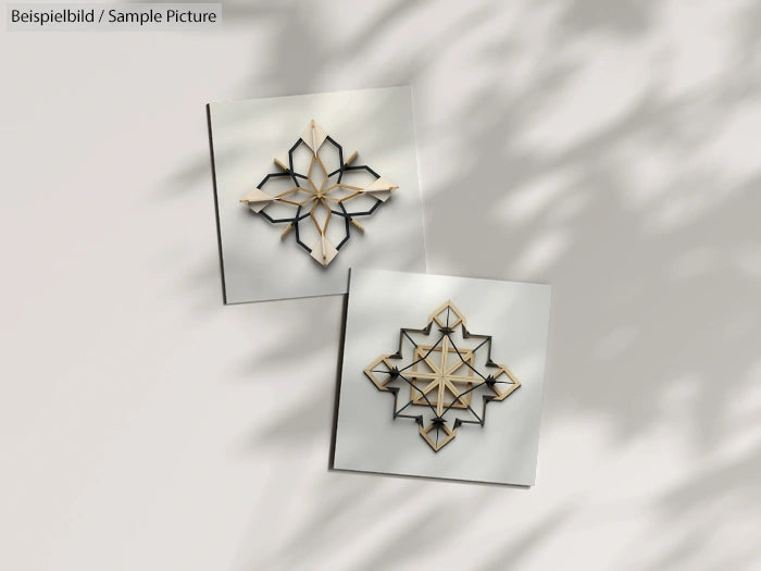 Two intricately designed geometric wall tiles with shadow patterns on a light background.