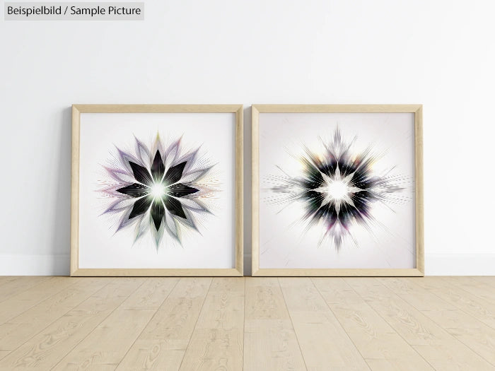 Two framed abstract starburst art prints on a wooden floor against a white wall.