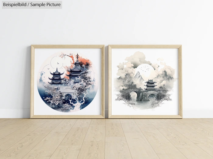 Two framed Asian landscape artworks with pagodas and mountains, in blue and white tones, displayed on wooden floor.