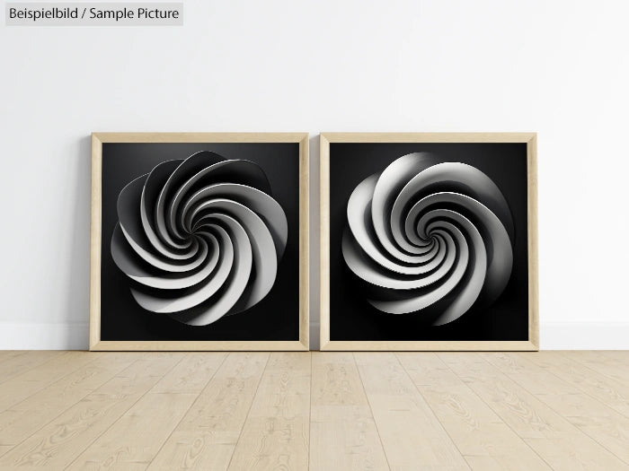 Two framed abstract artworks with spiral designs in black and white on a wooden floor.