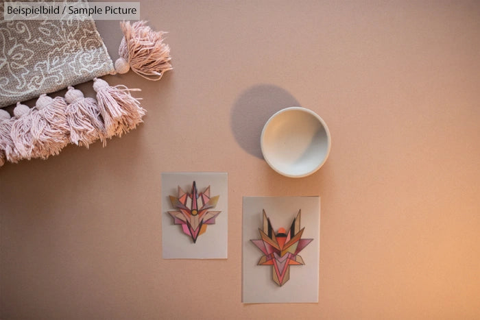 Flat lay of tribal patterns, a decorative fabric, and a small bowl on a soft, beige surface.