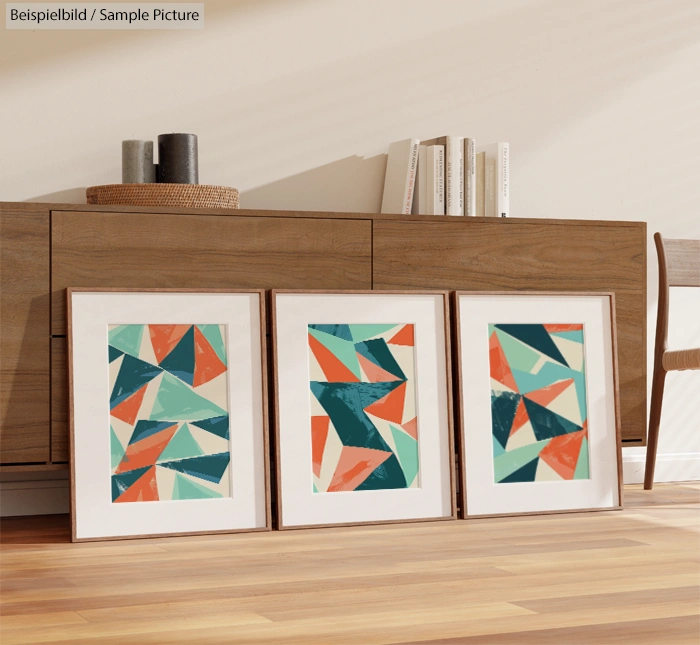 Three framed abstract geometric artworks on wooden floor near modern sideboard in minimalistic room.