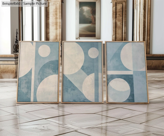 Three abstract geometric paintings with circles and rectangles in blue and white, displayed in a wooden frame.