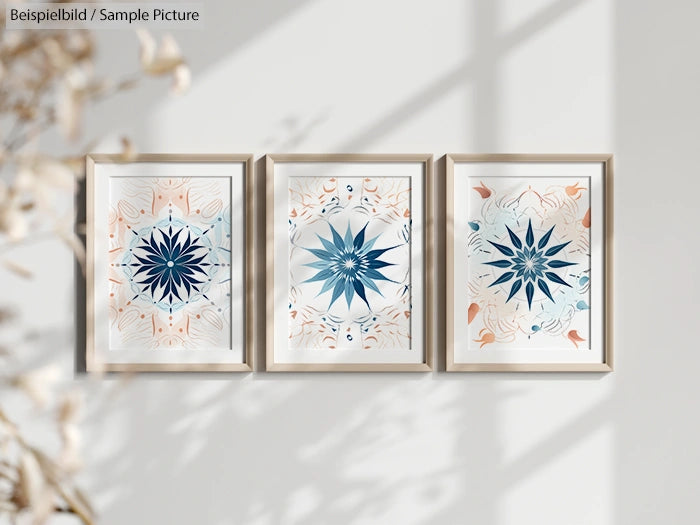 Three framed geometric mandala art prints on a white wall in sunlight.