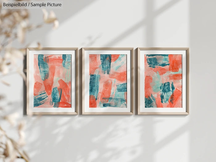 Triptych of abstract paintings with red and teal brushstrokes on canvas, framed and hung on a white wall.