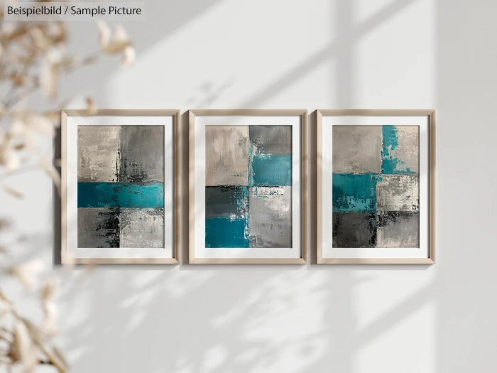 Triptych of abstract paintings with shades of teal, gray, and beige, framed and displayed on a light wall.