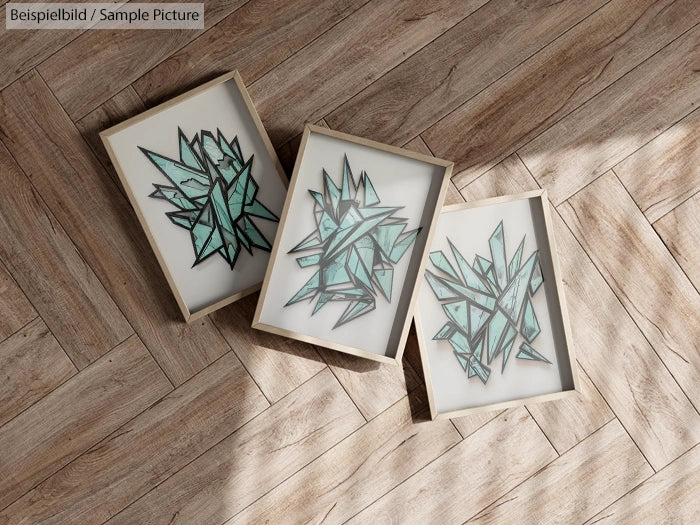 Three framed abstract geometric art pieces on a wooden herringbone floor.