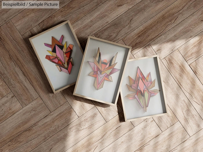 Three framed abstract geometric artworks on wooden floor.