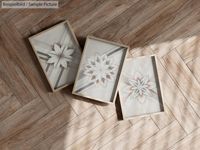 Three framed geometric floral artworks on a wooden herringbone floor.