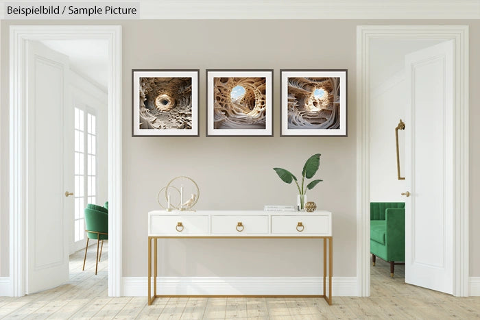 Modern interior with a console table, decorative objects, and three framed abstract artwork pieces on the wall.