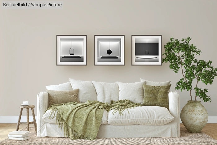 Living room with white sofa, green cushions, and three minimalist black and white framed photos on the wall.