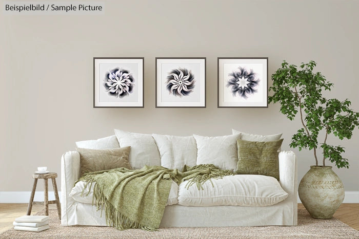 Living room with white sofa, green pillows, blanket, potted plant, and three abstract floral artworks on the wall.