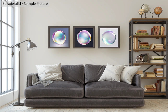 Modern living room with gray sofa, bookshelf, and three framed bubble artworks on the wall.