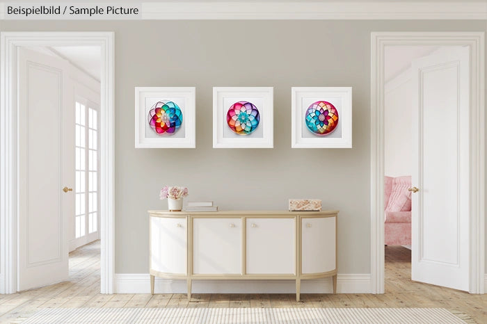 Modern living room with three colorful geometric paintings on a neutral wall, above a white console table.