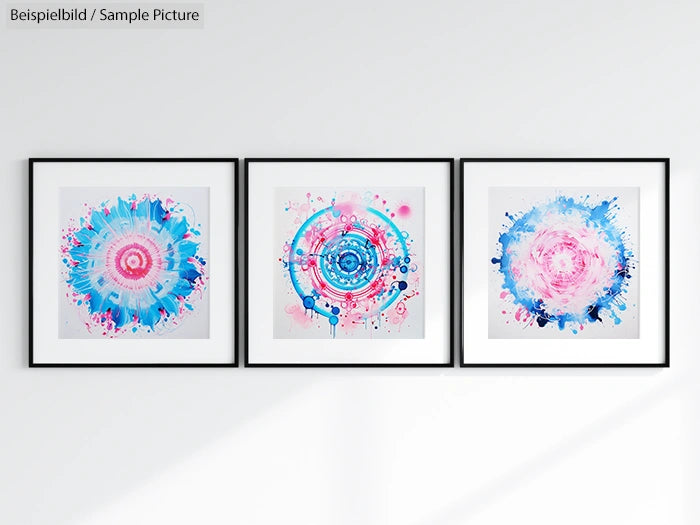 Three framed abstract paintings with vibrant pink and blue circular patterns on a white wall.