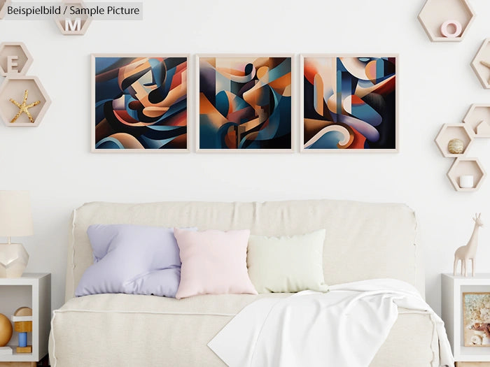 Modern abstract triptych with blue and orange shapes above a cozy white sofa and pastel cushions.