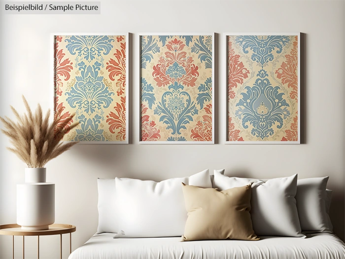 Living room with a white sofa, beige and gray cushions, and three framed floral prints on the wall in blue and orange hues.