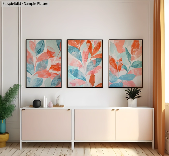 Modern living room with three abstract leaf paintings above a white sideboard.