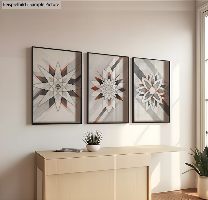 Minimalist room with geometric art triptych and small potted plant on a light wood sideboard.