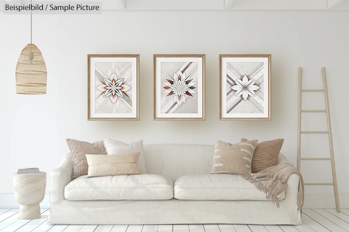 Modern living room with white sofa, beige cushions, layered rugs, and three geometric patterned artworks on the wall.