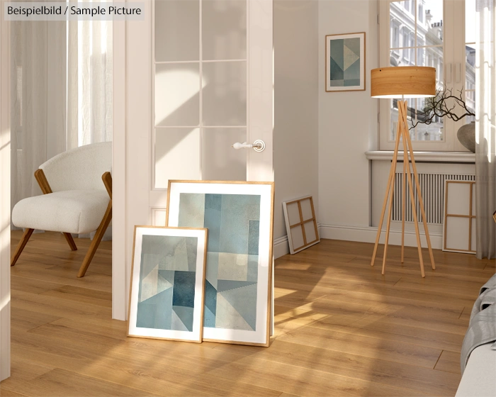 Cozy room with framed abstract art on wooden floor, standing lamp, and white armchair near glass door.