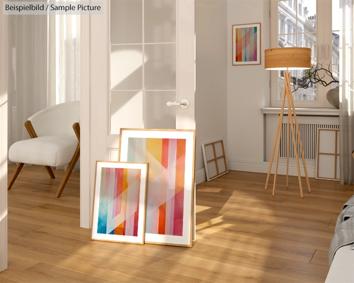 Bright room with wooden floor, abstract colorful paintings, chair, lamp, and large window letting in natural light.