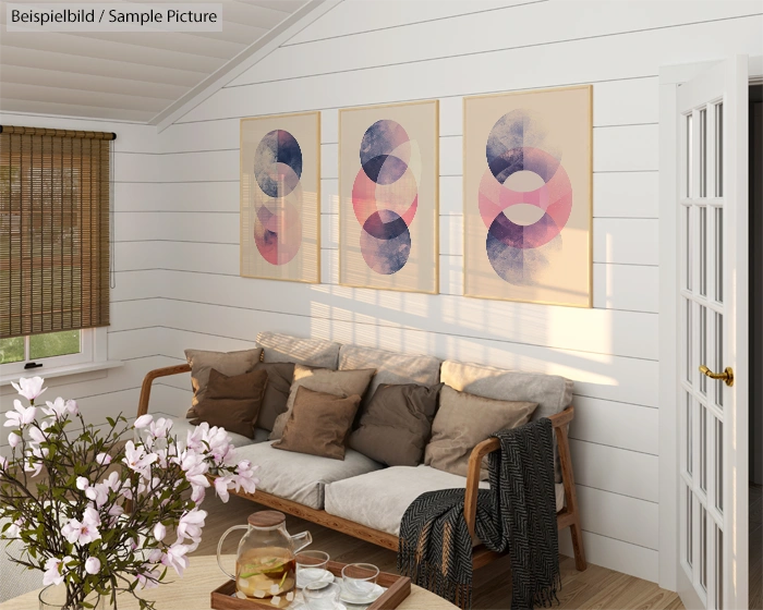 Cozy living room with beige sofa, abstract art on wall, wooden blinds, and a glass teapot on the wooden table.