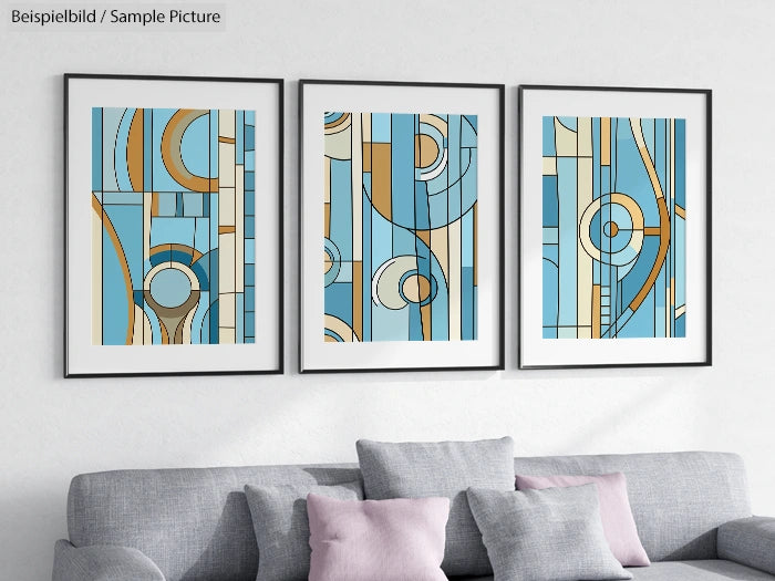 Modern abstract geometric prints in blue, beige, and peach tones, framed above a light gray sofa with cushions.