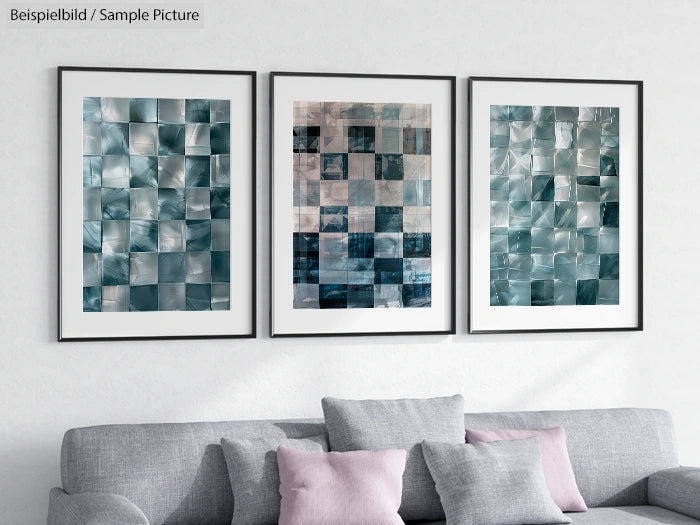 Triptych of abstract mosaic artworks in teal and gray, framed on a light wall above a gray sofa with pink cushions.