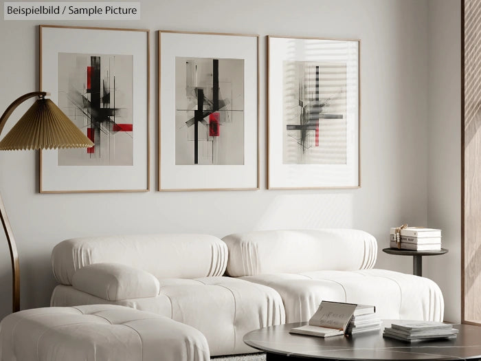 Modern living room with white couches, abstract art on wall, and a table with stacked books.