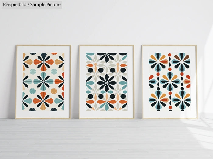 Three framed geometric flower artworks with blue, orange, and black patterns on white background.