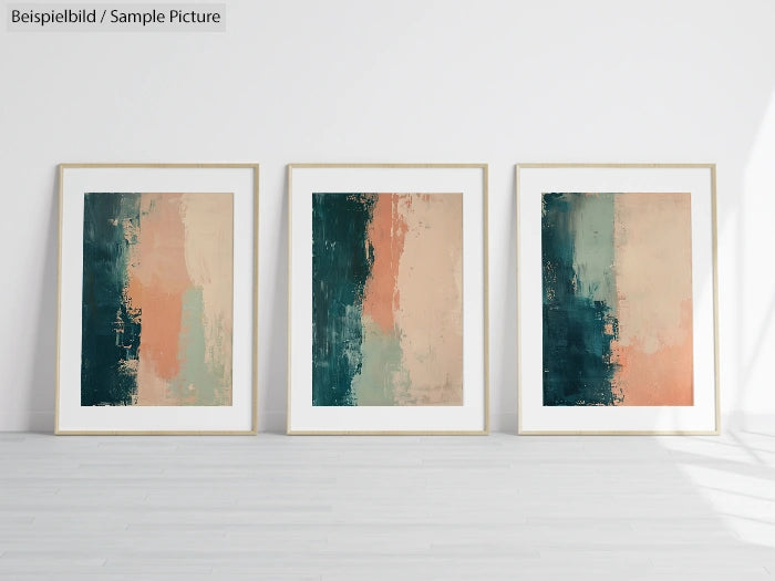 Trio of abstract paintings with blue, peach, and beige tones framed on a white wall in a modern minimalist setting.