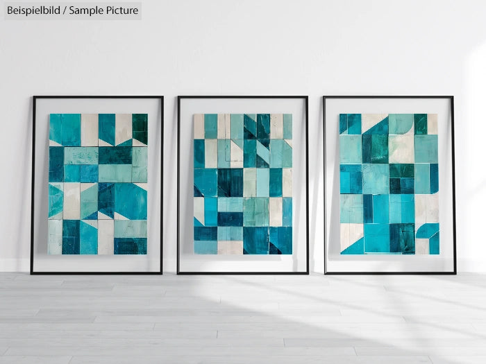 Three framed abstract geometric artworks in blue tones, displayed against a white wall on a light wood floor.