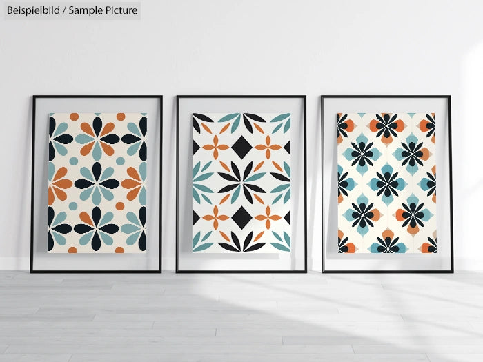 Three framed abstract floral prints with orange, blue, and black patterns on a white wall.