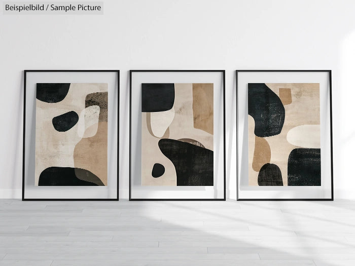 Three framed abstract paintings with black, beige, and white geometric shapes on a white wall.