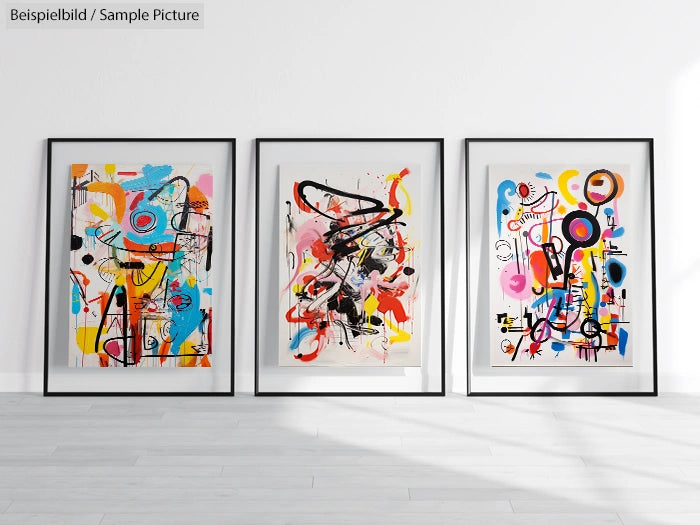 Three framed abstract paintings with colorful swirls, geometric shapes, and lines displayed against a white wall.