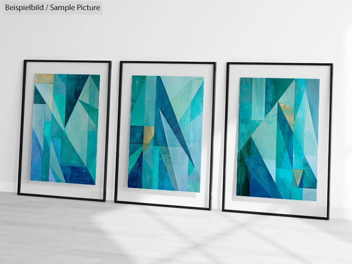 Three framed abstract paintings with geometric blue and green shapes displayed on a white wall.