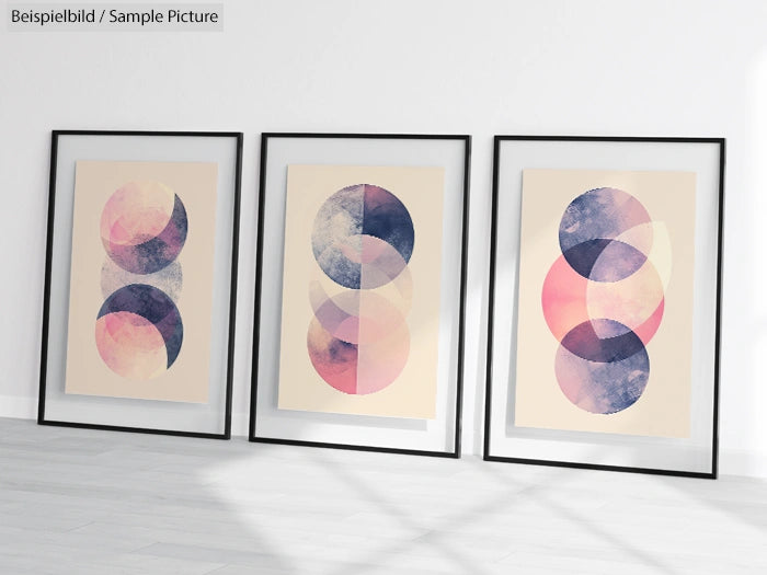 Three framed abstract art prints with overlapping pink and blue circular shapes on a light background.