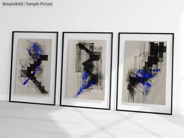 Three framed abstract artworks with black geometric shapes and blue accents, displayed against a white wall.