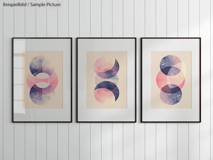 Three framed abstract prints with overlapping circles in pink, purple, and blue hues on a white wall.