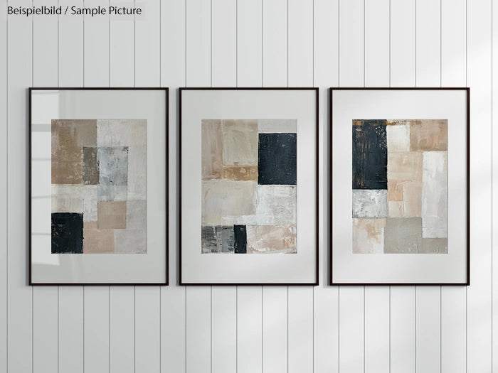 Three framed abstract paintings with geometric shapes and neutral tones on a white paneled wall.