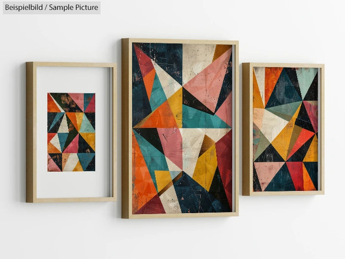 Three framed geometric abstract artworks with colorful triangles and polygons displayed on a white wall.