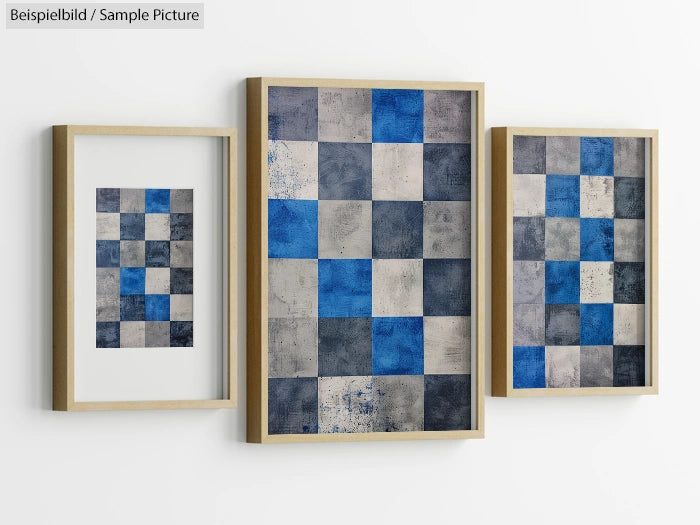 Three framed checkered abstract paintings with blue, gray, and white squares, displayed on a white wall.