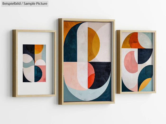 Set of three framed abstract geometric art prints with blue, orange, and pink shapes on a white wall.