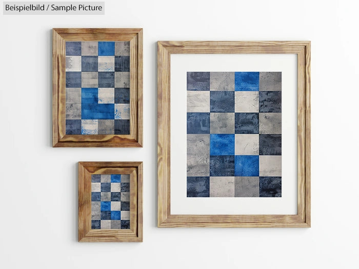 Three framed mosaic art pieces with blue and gray squares, arranged on a white wall.