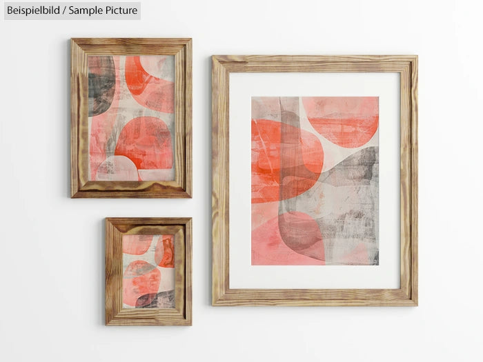 Three abstract paintings with warm tones in wooden frames on a white wall.