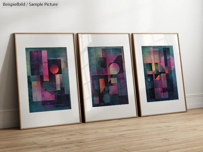 Three framed abstract geometric artworks with bold colors on a wooden floor against a beige wall.