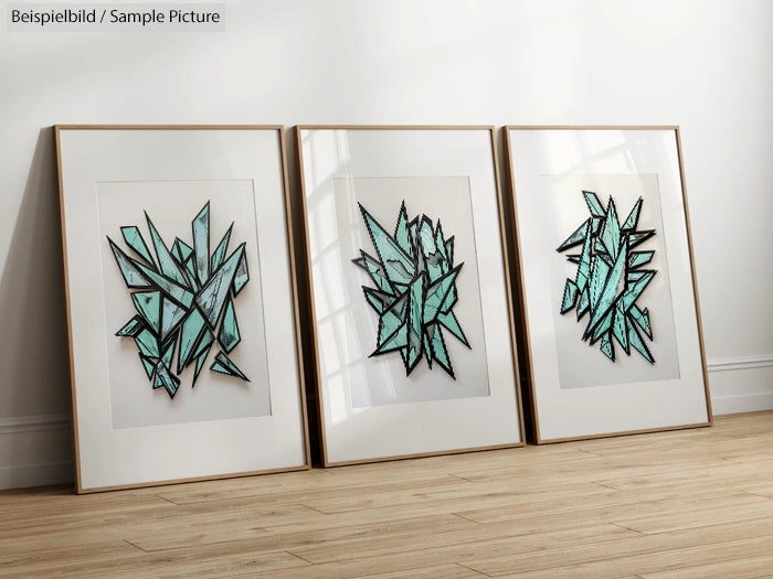 Triptych of abstract geometric art with teal and black lines in white frames, displayed on a wooden floor.