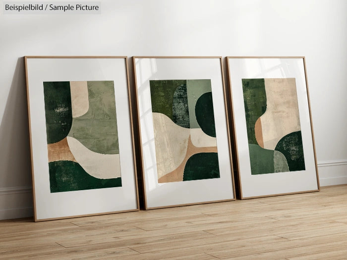 Set of three abstract art prints with green, beige, and brown geometric shapes, framed on a wooden floor.